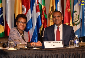 Food and Agriculture Organization (FAO) Sub-regional Director (ad interim), Dr. Lystra Fletcher-Paul (left), and Director of Projects at the Caribbean Development Bank (CDB), Mr. Daniel Best (right),  shake hands after signing  Framework Cooperation Agreement, today (March 5), at the 35th staging of the Regional Conference for Latin America and the Caribbean, in Montego Bay.