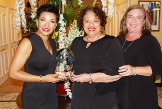 Jamaica’s Ambassador to the United States, Her Excellency Audrey Marks, presents a plaque to Joyce Spence in recognition of her 20 years as Appleton Estate master blender and the first female to hold this position in the spirits industry.  Occasion was a function held at the Jamaican Embassy in Washington D.C on February 4 to honour the master blender. Sharing in the occasion is J. Wray & Nephew’s Global Brand Public Relations Manager, Catherine McDonald.   