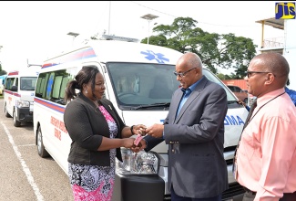 Regional Director for the South East Regional Health Authority (SERHA), Maureen Golding hands over keys for an ambulance to Chairman of the Princess Margaret Hospital, Michael McLeod, during a ceremony on January 3 at the Bustamante Hospital for Children in Kingston. At right is Chief Executive Officer for the Bustamante Hospital for Children, Anthony Wood.