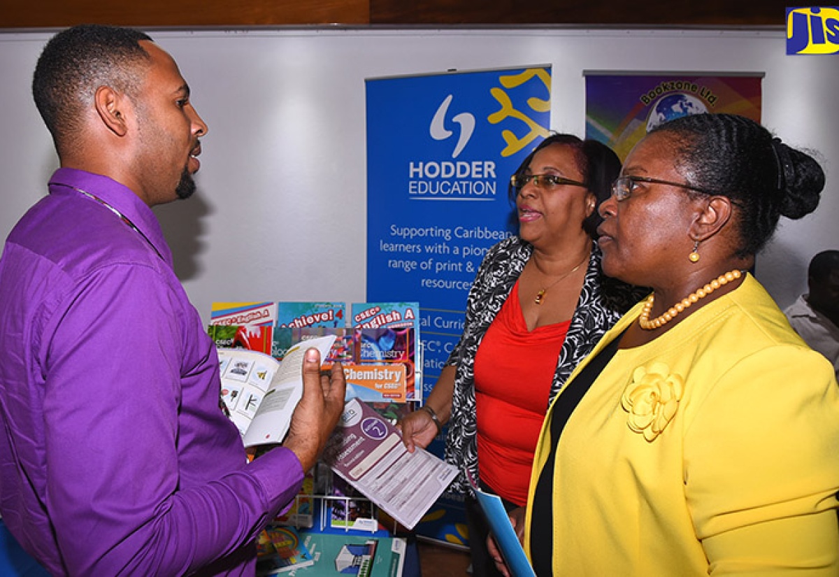 Deputy Chief Education Officer in the Ministry of  Education, Youth and Information, Maxine Headlam (right), and President of the Jamaica Independent Schools’ Association (JISA), Karlene Bisnott (second right),  speak to Sales and Marketing Executive, Hodder Education, Frank Mark Phipps, about some of the books the company publishes and distributes. They were visiting booths mounted as part of the annual general meeting of JISA, held at the Jamaica Conference Centre in downtown Kingston on January 31. 

