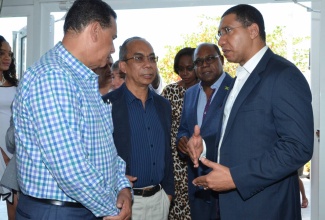 Prime Minister, the Hon. Andrew Holness (right) speaks with (from left): Montego Bay’s Mayor, Councillor Homar Davis; Minister without Portfolio in the Ministry of Economic Growth and Job Creation, Hon. Dr. Horace Chang; and Tourism Minister, Hon. Edmund Bartlett, at the official opening of the Royal DeCameron Cornwall Beach Resort in Montego Bay, St. James on Saturday February 18. In the background is the wife of the Prime Minister, the Most Hon. Juliet Holness.  