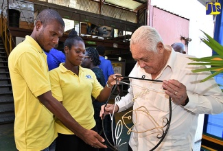 Minister without Portfolio in the Office of the Prime Minister and Member of Parliament for Central Clarendon, Hon. Michael Henry (right), admires the work of welding students of the Wesley E. McLaren Hazard Skills Training Centre (from left) Dennis Morrison; and Chrissy Grant. Occasion was a handover ceremony for the Wesley E. McLaren Hazard Skills Training Centre on the grounds of the McLaren Engineering Company in Clarendon on Friday (April 6). 