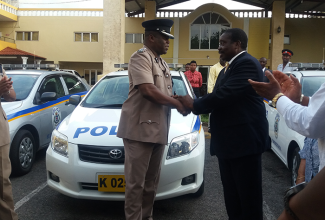 Minister of National Security,  Hon. Robert Montague (right), presents the keys to one of four preowned cars to Superintendent Wayne Cameron of the Mandeville Police Station at the Golf View Hotel in Mandeville on July 6.  The Minister also addressed the Manchester Chamber of Commerce meeting at the same venue.