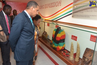 Prime Minister the Most Hon. Andrew Holness (right), and Minister of Culture, Gender, Entertainment and Sport, Hon. Olivia Grange, look at memorabilia on display at the opening of a museum honouring the life and work of late reggae icon Peter Tosh at the  Pulse Centre, Trafalgar Road on October 19.