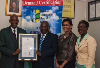 Chairman of the National Council on Technical Vocational Education and Training (NCTVET), Norman Davis (left); and Chairman of the National Certification Body of Jamaica (NCBJ), Dr. Neville Swaby (2nd left), proudly display the International Organization for Standardization (ISO) 9001 certification, which has been transferred to the NCBJ, the local certification body. Sharing the moment are Acting Senior Director of the NCTVET, Jennifer Walker (2nd right); and Manager at the NCBJ, Jacqueline Scott-Brown. 

