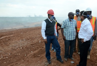 Minister of Local Government and Community Development, Hon. Noel Arscott (right), along with (from left):  Director-General of the Office of Disaster Preparedness and Emergency Management, Major Clive Davis; Regional Operations Manager, Metropolitan Parks and Markets, Adrian Grant, and Supervisor, Riverton City Disposal Site,  Larel Thomas observe the work being done to extinguish the fire at the Riverton City disposal site, during a tour of the facility on Friday, March 20.