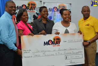 Director of Sector Support Services at the Early Childhood Commission (ECC) Nordia Seymour-Hall (second right), displays a symbolic cheque for $3.5 million, courtesy of the organisers of the annual MoBay City Run charity event, during the presentation ceremony at the University of the West Indies (UWI) Western Jamaica Campus on Tuesday (March 6). Sharing in the moment (from left) are Acting Director, University of the West Indies, Western Jamaica Campus, Patrick Prendergast; Montego Bay Community College Lecturer, Vinette Fearon-Hall; University of Technology Western Campus Coordinator, Sophia McIntosh; and Executive Member of the MoBay City Run organizing committee, Conroy Thompson.