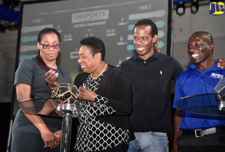 Minister of Culture, Gender, Entertainment and Sport, Hon. Olivia Grange (second left), conducts the official draw for the INSPORTS Primary School football and netball competitions on January 15 at the National Indoor Sports Centre in Kingston. Observing (from left) are Oberon “OB” Pitterson-Nattie, Ian “Pepe” Goodison and Sport Officer, INSPORTS, Kevin Morrison.

