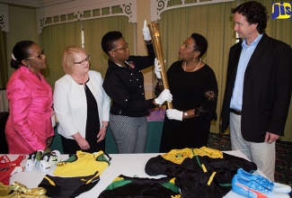 A close look is being taken at a replica of the 2012 London Olympics torch by the Honourable Olivia Grange, Minister of Culture, Gender, Entertainment and Sport (second left); Florette Blackwood, Senior Director, Sport Development and Monitoring Division in the Ministry; Janice Smith, National Sport Museum Consultant; Colleen Nattie, Conservation Officer, National Museum Jamaica and Dr Johnathon Greenland, Curator, National Museum Jamaica (left to right). The torch along with other donated items for the National Sport Museum was on display at the Textile Conservation, Preservation and Exhibition Workshop today (Wednesday) at the Knutsford Court Hotel in Kingston.