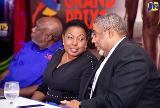 Minister of Culture, Gender, Entertainment and Sport,  Hon. Olivia Grange (centre), in  conversation with Assistant General Manager of the Jamaica National (JN) Foundation, Leon Mitchell (right), at the  press launch for the Jamaica National (JN) Racers Grand Prix at The Jamaica Pegasus hotel in Kingston.  At left is President of Racers Track Club, Dr. the Hon. Glen Mills. The meet is slated to be held on Saturday, June 9 at the National Stadium in Kingston. 