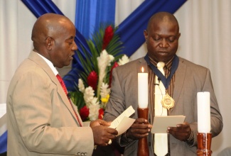 Principal of the Four Paths Primary and Junior High School in Clarendon , Norman Ansel Allen (right), is installed as the 51st President of the Jamaica Teachers Association (JTA), during Monday night’s (17)  session of the JTA’s annual conference, now underway at the Hilton Rose Hall Resort and Spa in Montego Bay St. James.  Outgoing President, Doran Dixon, officiated the function.
