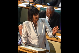 Prime Minister the Most. Hon. Portia Simpson Miller makes a point during her presentation in the 2015/16 Budget Debate, in the House of Representatives on Tuesday, March 24. Mrs. Simpson Miller’s presentation was made under the theme - ‘Moving Forward: Jobs, Growth and Development’.  At left is Minister of Finance and Planning, Dr. the Hon. Peter Phillips.