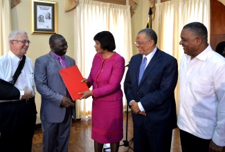 Prime Minister, the Most. Hon. Portia Simpson Miller (centre), presents a copy of the signed wage agreement to President, Jamaica Teachers’ Association (JTA), Norman Allen. The JTA signed a new two-year wage agreement with the Government on Wednesday, August 26 during a ceremony held at Jamaica House today (Aug. 26). Looking on (from left) are: Minister of Education, Hon. Rev. Ronald Thwaites; Minister of Finance and Planning, Dr. the Hon Peter Phillips; and Minister without Portfolio in the Ministry of Finance and Planning, Hon. Horace Dalley.
