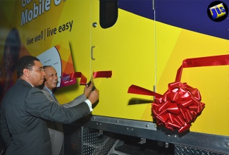 Prime Minister, the Most Hon. Andrew Holness (right) and Guardian Life Limited President, Eric Hosin, cut the ribbon to officially open the Guardian Life Mobile Medical Unit, at their headquarters in New Kingston, on July 21. 