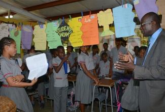 Minister of Education, Youth and Information, Senator the Hon. Ruel Reid (right), interacts with students of the Padmore Primary School during a tour of the institution located in Red Hills, St. Andrew on Thursday, April 7. 