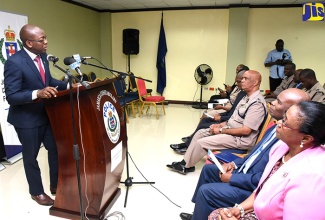 State Minister, Ministry of National Security, Senator the Hon. Pearnel Charles Jr., addresses a  dedication ceremony at  the office of the Commissioner of Police in Kingston today (January 2). Seated at third right is the Commissioner, Mr. George Quallo. 