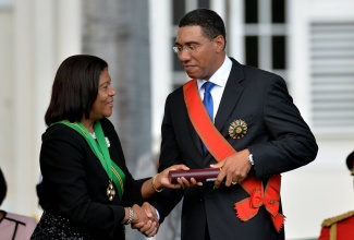 Prime Minister, the Most Hon. Andrew Holness, is presented with the instrument of conferment of the Order of the Nation (ON) by Chief Justice and Chancellor of the ON, Hon. Zaila McCalla, during Thursday’s (March 3) swearing in ceremony at King’s House.