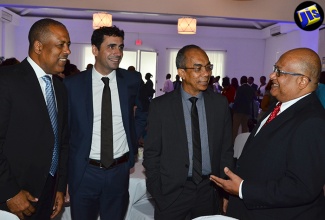 Minister without Portfolio in the Ministry of Economic Growth and Job Creation, Hon. Dr. Horace Chang (2nd right), having a light discussion with Chief Executive Officer (CEO)/Commissioner of Jamaica Customs Agency, Major Richard Reese (right), during the official launch of the Port Authority of Jamaica’s (PAJ) Port Community System (PCS) on July 12, at the Spanish Court Hotel in Kingston. Others (from left) are: President and Chief Executive Officer (CEO) of the PAJ, Professor Gordon Shirley, and Project Manager for port operations management facilitator, SOGET SA, Benoit Basset. 