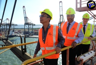 (From left) Minister without Portfolio in the Ministry of Economic Growth and Job Creation, Hon. Dr. Horace Chang; President of the Port Authority of Jamaica, Professor Gordon Shirley; and Chief Executive Officer (CEO) of Kingston Freeport Terminal Limited (KFTL), Olivier Tretout take a ride on a container-handling gantry crane during a tour of the Port of Kingston, on July 20. 