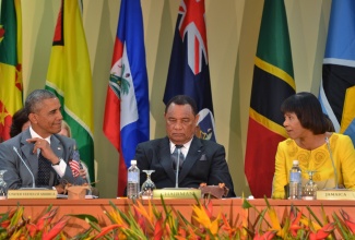 Prime Minister, the Most Hon. Portia Simpson Miller (right), makes a comment to President of the United States,  Barack Obama (left), during the Caribbean Community (CARICOM)-US Summit today (April 9), at the University of the West Indies, Regional Headquarters in St. Andrew). Also pictured is Chairman of CARICOM, and Prime Minister of The Bahamas, Hon. Perry Christie. 