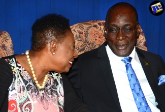 Minister of Culture, Gender, Entertainment and Sport, Hon. Olivia Grange (left), engages in light conversation with Minister of Education, Youth and Information, Senator the Hon. Ruel Reid, during a post-Cabinet press briefing held on July 27 at the Office of the Prime Minister.