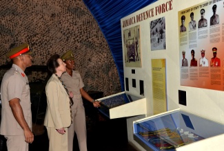 Her Royal Highness, the Princess Royal, Princess Anne, is given a history of the Jamaica Defence Force (JDF) by Curator of the Military Museum, Stacey Duhaney (right), while Chief of Defence Staff, Major General Antony Anderson, looks on. Her Royal Highness toured Up Park Camp on October 1, as part of her three-day visit to the island from September 30 to October 2.