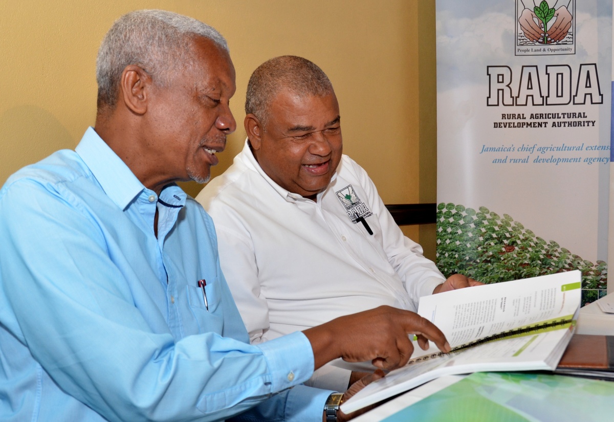 Chief Executive Officer, Rural Agricultural Development Authority (RADA), Lenworth Fulton (right), and Food and Agriculture Organization of the United Nations (FAO) representative in Jamaica, Dr. Jerome Thomas, look through a copy of the ‘Best Land Husbandry Practices and Climate Smart Agriculture Manual, during a handing over ceremony today (January 16), at the Ministry of Agriculture and Fisheries’ Veterinary Services Division in Kingston.