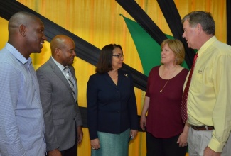 Caption: Minister of Labour and Social Security,  Hon. Shahine Robinson (centre), in discussion with Managers at Gebbers Farms in Washington, United States, Catherine Grandy (second right) and Bob Grandy (right), after the Gebbers Farms management and workers academic grants presentation ceremony  on May 5 at the Ministry’s North Street office. Listening are Supervisor at Gebbers Farms, Eyon Gayle (left) and Liaison Officer, Sheldon Brown.