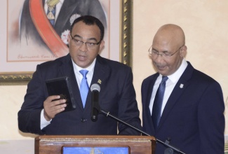 Governor General Sir Patrick Allen looks on as Dr. Hon. Christopher Tufton is sworn in as Minister of Health.