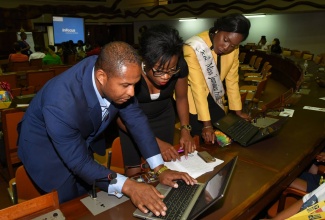 United Kingdom-based entrepreneur, Nathaniel Peat (left), preparing for his presentation at the Global Young Leaders Forum at the Jamaica 55 Diaspora Conference on Wednesday, July 26. Assisting him is 2017 recipient of the Governor-General’s Achievement Award – Diaspora, Taneisha Westcarr (centre), while Miss Jamaica Festival Queen 2016, Kyesha Randall, looks on. The forum was held at the Jamaica Conference Centre in downtown Kingston.