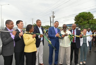 Prime Minister, the Most Hon. Andrew Holness (centre), cuts the ribbon to officially open the newly upgraded 2.44-kilometre section of Marcus Garvey Drive, between East Avenue and Harbour Street in Kingston, on Thursday, October 5. The US$20.5 million project was implemented by the Ministry of Economic Growth and Job Creation through the National Works Agency (NWA) and executed by China Harbour Engineering Company Limited (CHEC) under the Government’s Major Infrastructure Development Programme. Sharing in the occasion (from left) are Kingston’s Mayor, Senator Councillor Delroy Williams; Ambassador of the People’s Republic of China to Jamaica, His Excellency Niu Qingbao; Permanent Secretary in the Office of the Prime Minister/Ministry of Economic Growth and Job Creation, Audrey Sewell; Opposition Spokesman on Works, Mikael Phillips; Local Government and Community Development Minister and Member of Parliament for West Kingston where the roadway is located, Hon. Desmond McKenzie; NWA Chief Executive Officer, E.G. Hunter; CHEC Deputy General Manager, Dr. Zhimin Hu; and NWA Communication and Customer Services Manager, Stephen Shaw.
