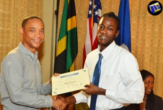 President of the Private Sector Organization of Jamaica (PSOJ), Dennis Chung, presents a certificate of participation to Ryan Stewart for completing the ‘Pitch It’ initiative, at an awards ceremony, held on August 12 at the Mona Visitors’ Lodge in St. Andrew. Mr. Stewart was one of 21 persons who received business start-up grants valued at $6 million. The initiative was implemented by Organization of American States (OAS), the Trust for the Americas and Junior Achievement Jamaica, with financial support from the United States Agency for International Development (USAID).  