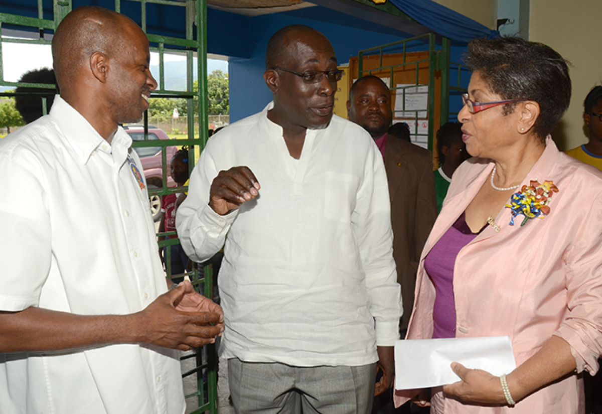 Education, Youth and Information Minister, Senator the Hon. Ruel Reid (centre), engages Kiwanis Club Lieutenant Governor, Beverley Thompson (right), in discussion during the service organization’s annual Division 23 East youth rally at Ardenne High School in Kingston, on Saturday, May 7. Listening keenly is Distinguished Lieutenant Governor for Division 23, Lloyd Distant. 