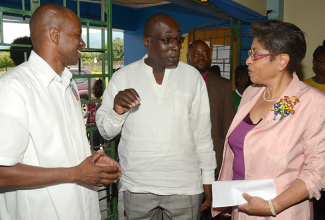 Education, Youth and Information Minister, Senator the Hon. Ruel Reid (centre), engages Kiwanis Club Lieutenant Governor, Beverley Thompson (right), in discussion during the service organization’s annual Division 23 East youth rally at Ardenne High School in Kingston, on Saturday, May 7. Listening keenly is Distinguished Lieutenant Governor for Division 23, Lloyd Distant. 