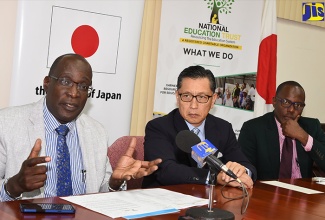 Minister of Education, Youth and Information, Senator the Hon. Ruel Reid (left), speaks at the signing of a grant agreement with the Japan Grassroots Human Security Project at the Office of the Prime Minister on January 10. Listening (from second left) are:  Ambassador of Japan to Jamaica, His Excellency Hiromasa Yamazaki, and Principal, Oracabessa Primary School, Gregory Davis.