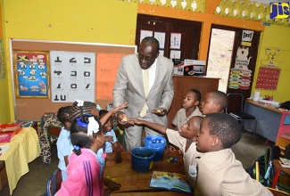 Minister of Education, Youth and Information, Senator the Hon. Ruel Reid, interacting with grade-one students at Jack’s Hill Primary School in rural St. Andrew during his visit on Monday, January 15.