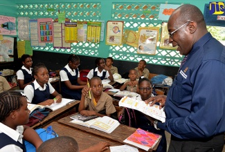 Minister of Education, Youth and Information, Senator the Hon. Ruel Reid (right), conducts a mathematics class at the Frankfield Primary and Infant School in Clarendon, when he visited the institution on January 16. 