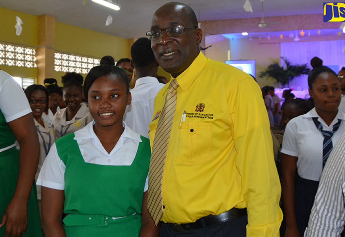 Minister of Education, Youth and Information, Senator the Hon. Ruel Reid with grade-10 student, Atoya Anderson, of Frome Technical High School after delivering the keynote address at the launch of the Ministry/Joint Committee for Tertiary Education Symposium and Expo held at the St. Hilda’s Diocesan High School, in St. Ann, on February 28.