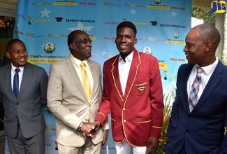 Education, Youth and Information Minister, Senator the Hon. Ruel Reid (second left), greets Child Protection and Family Services Agency (CPFSA) awardee, Sanjay Carter (second right), at an awards ceremony for youngsters in State care organised by the agency, at the Terra Nova All-Suite Hotel in Kingston on November 22.  Others (from left) are State Minister in the Education, Youth and Information Ministry, Hon. Floyd Green; and Attorney-at-law, John Clarke. 