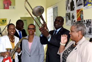 Minister of Education, Youth and Information, Senator the Hon. Ruel Reid (second right), tries out a trombone during a tour of the Alpha Institute’s South Camp Road campus in Kingston on Tuesday (November 21). Sharing the moment (from left) are Ministry of Education Region One Director, Kasan Troupe; Principal, Alpha Institute, Janet Grant; and School Administrator, Margaret Little Wilson.

