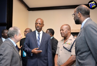 Commissioner of Police, Dr. Carl Williams (second left), in discussion with United Nations Special Envoy for Road Safety, Jean Todt (left),  at a road-safety luncheon, held on August 9, at The Jamaica Pegasus hotel, in New Kingston. Others (from third left) are Head of the Traffic and Highway Division, Senior Superintendent of Police, Calvin Allen and President of the Jamaica Automobile Association, Earl Jarrett.