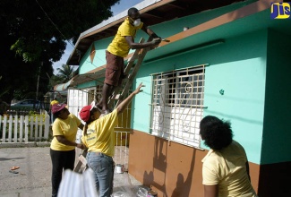 Chief Executive Officer (CEO) of the Real Estate Board (REB)/Commission of Strata Corporations, Sandra Watson Garrick (second right), points out an area for painting during a ‘work’ day at the facility on December 8.

