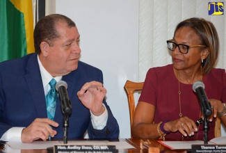 Finance and the Public Service Minister, Hon. Audley Shaw (left), emphasises a point to Inter-American Development Bank (IDB) Country Department Caribbean Group General Manager, Therese Turner-Jones, after both signed an agreement formalising the IDB’s authorisation of partial use of Jamaica’s public-procurement system guidelines for implementing projects funded by the multilateral institution. The signing took place at the Ministry’s National Heroes Circle offices in Kingston on January 11.