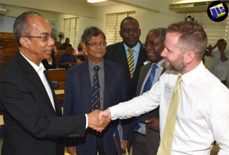 Minister without Portfolio in the Ministry of Economic Growth and Job Creation, Hon. Dr. Horace Chang (left), is greeted by Research Fellow, Institute for Advanced Sustainability Studies, Germany and Project Director at the Solar Radiation Management Governance Initiative (SRMGI), Mr. Andy Parker (right), at a workshop at the University of the West Indies (UWI), Mona,  on July 7. The workshop was held to facilitate discussion on a solar radiation management (SRM) theory to reduce global warming. Also pictured are (from left) President of the Caribbean Academy of Sciences, Jamaica, Professor Tara Dasgupta; Senior Advisor on Energy in the Ministry of Science, Energy and Technology, Mr. Dwight Lewis; and Dean in the UWI Faculty of Science and Technology, Professor Ishenkumba Kahwa. The workshop was hosted by the UWI, in collaboration with SRMGI; the Caribbean Academy of Sciences, Jamaica; and Build Better Jamaica.