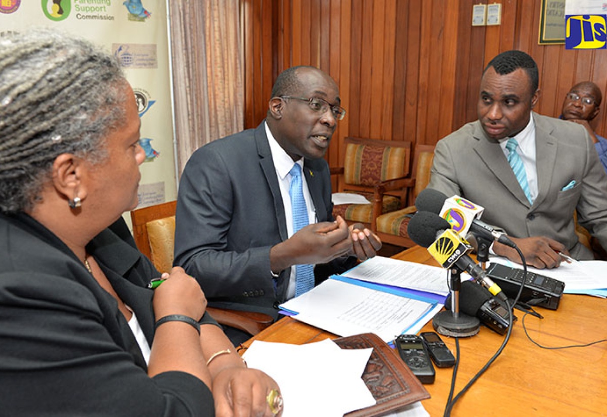 Education, Youth and Information Minister, Senator the Hon. Ruel Reid (centre), emphasises a point at a press conference at his Heroes Circle offices in Kingston on May 1. Others looking on are Senior Advisor to the Minister, Sharon Hay-Webster and Permanent Secretary in the Ministry, Dean-Roy Bernard. 