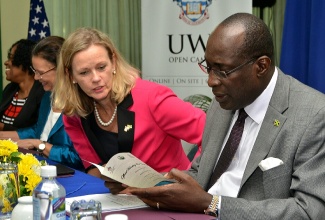 Minister of Education, Youth and Information, Senator the Hon. Ruel Reid (right) and Mission Director for the United States Agency for International Development (USAID) in Jamaica, Maura Barry Boyle (second right) in discussion at the handover of a Mobile Mental Health Unit, ‘Smile Mobile,’ to the Child Development Agency (CDA), in Kingston,  on April 7. The unit is to assist in strengthening the capacity of the CDA to provide psychological assessment and treatment of youth who have been traumatised by various acts of violence and abuse.