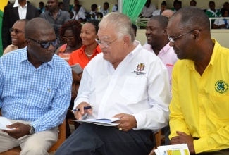 Minister of Industry, Commerce, Agriculture and Fisheries, Hon. Karl Samuda (centre), in discussion with Chairman of the Jamaica 4-H Clubs, Norman Grant (left), at the 4-H Clubs 2016 National Achievement Expo, held at the Denbigh Showground, in May Pen, Clarendon, on April 29.  At right is Executive Director of  the Jamaica 4-H Clubs,  Dr. Ronald Blake.