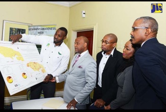 Trainer in the National Spatial Data Management Division (NSDSM) in the Ministry of Economic Growth and Job Creation, Jumaine Remikie (left), displays a map on the chikungunya and dengue fever outbreak in Jamaica in relation to hospital service areas, which was generated through the use of geographical information systems (GIS) technology. Looking on (from 2nd left) are: Land Information Council of Jamaica (LICJ) Chairman, Alexander Williams; NSDSM Principal Director, Rohan Richards; Acting Director, Crime Prevention Community Safety at the Ministry of National Security, Keisha Wright; and Chief Technical Director in the Ministry of Economic Growth and Job Creation, Lt. Col. Oral Khan. Occasion was the launch of Geography Awareness Week and the LICJ 25th anniversary celebrations on February 1 at The Knutsford Court Hotel, New Kingston, under the theme: ‘Geospatial Technologies – National Security and Public Safety’.