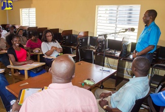 Minister without Portfolio in the Ministry of Industry, Commerce, Agriculture and Fisheries, Hon. J.C. Hutchinson (right), speaks with farmers attached to the Thompson Town Achievers Benevolent Society in Clarendon, at the Thompson Town Community Centre in the parish on April 28.