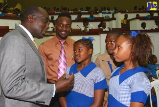 Minister of Education, Youth and Information, Senator the Hon. Ruel Reid (left), interacts with students of the St. Patrick Primary School while teacher Orlando Sculley (2nd left) looks on. Occasion was the National Careers Week 2017 regional forum at the Jamaica Conference Centre in downtown Kingston today (Feb. 16). The students are (from left): Tamilia Minott, Adriano Harris and Nyoka Betton.
 
